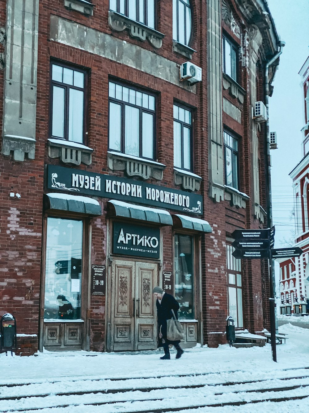a man walking in front of a building in the snow