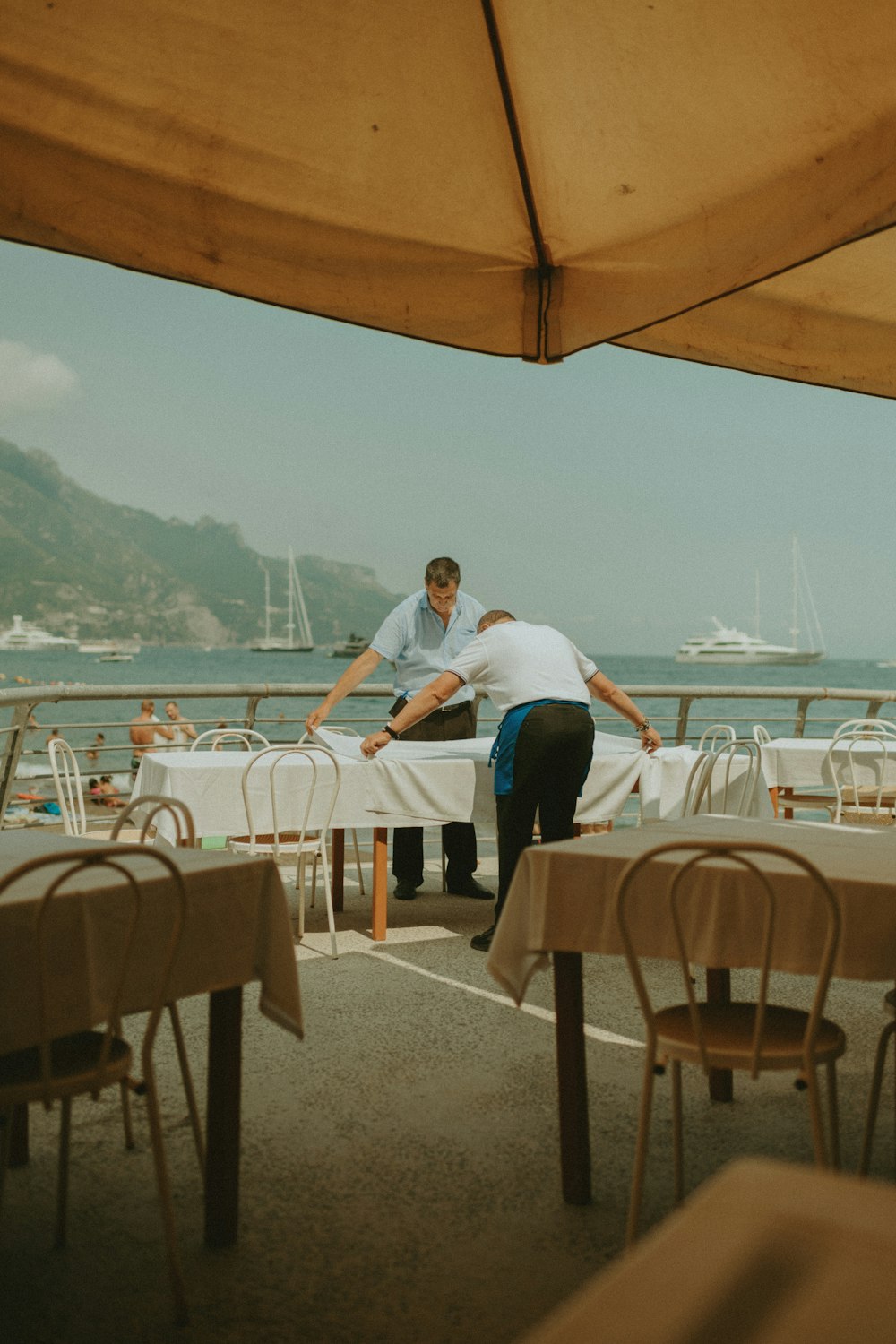 a couple of men standing next to each other near tables