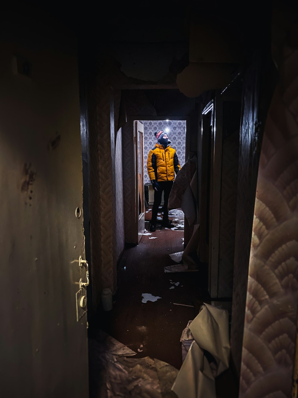 a man in a yellow jacket standing in a hallway