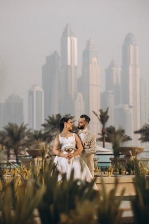 a bride and groom standing in front of a city skyline