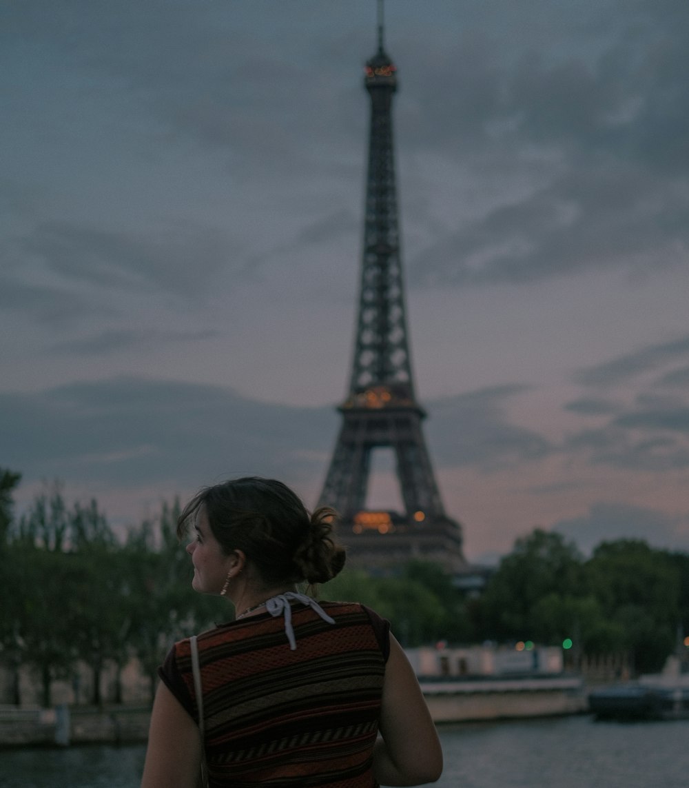 a woman standing in front of the eiffel tower