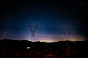Nighttime shot of energized power infrastructure glowing under a starry sky at Windmere Farm.