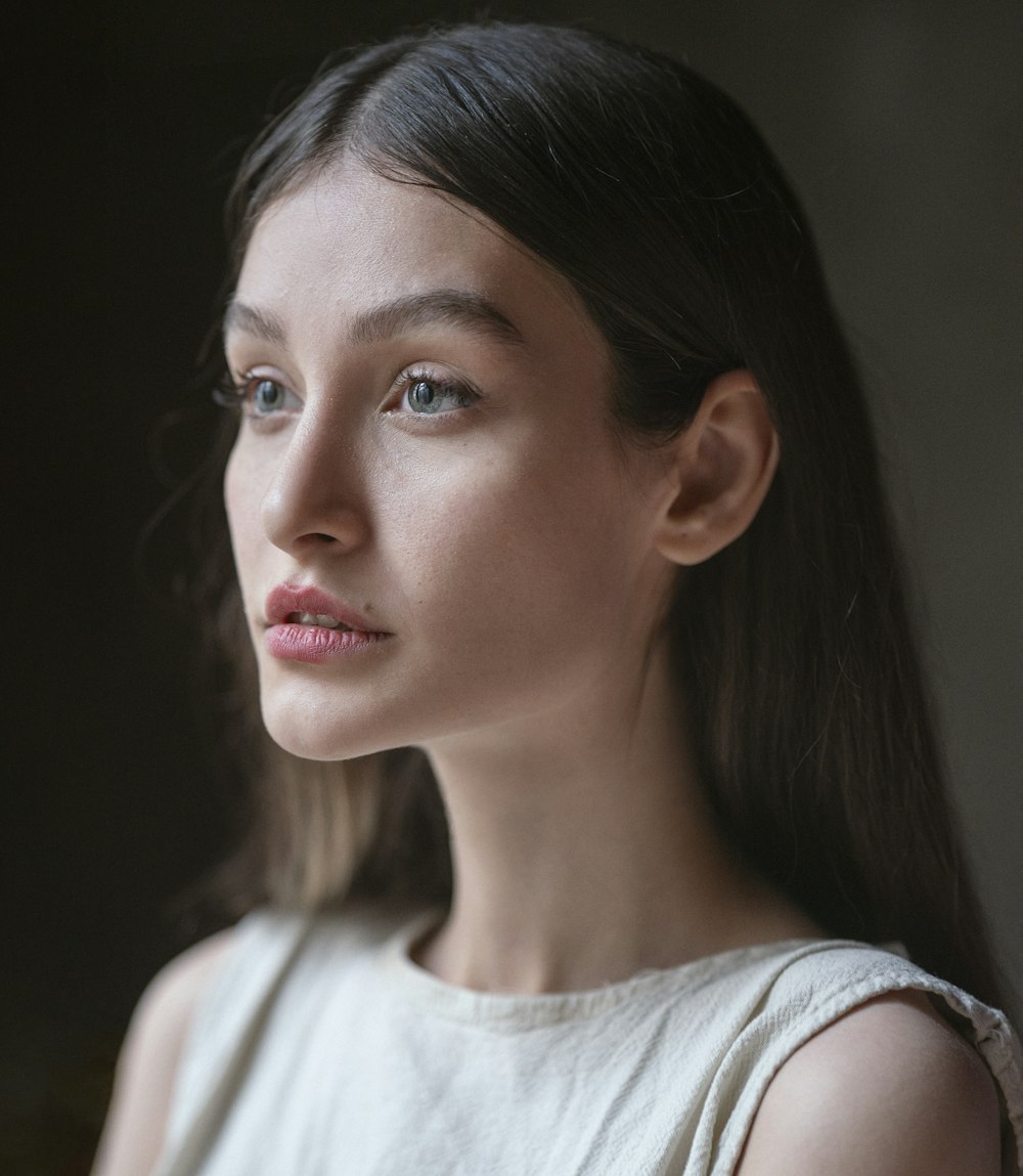 a woman in a white dress looking off into the distance