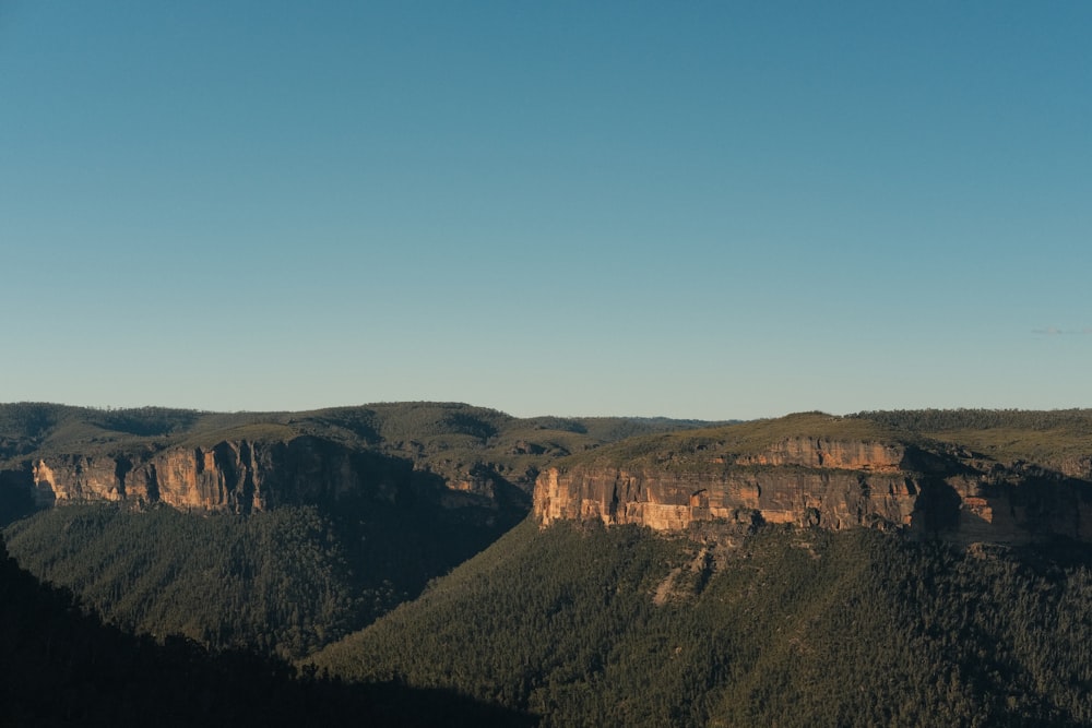 Una vista panorámica de una cadena montañosa con un cielo azul claro