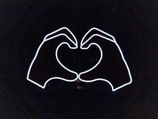 Logo of a community health group featuring a heart and helping hands.