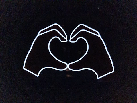 Logo of a community health group featuring a heart and helping hands.