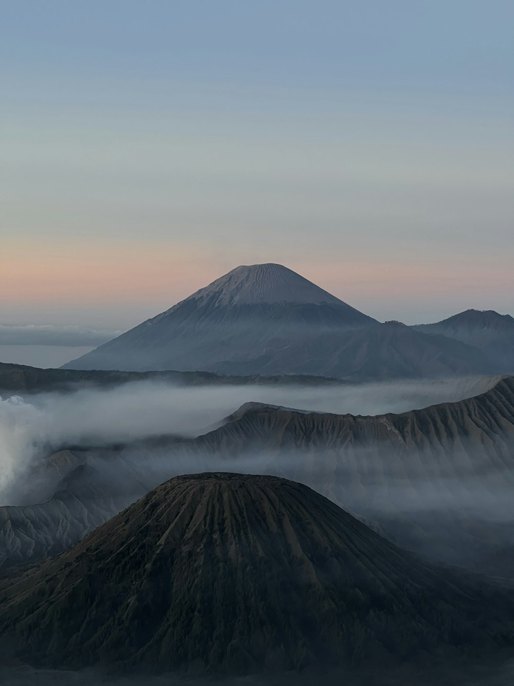 a view of a mountain range with low clouds in the foreground