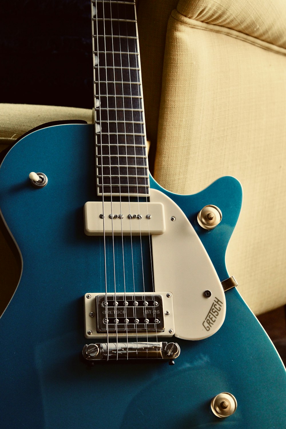 a blue guitar sitting on top of a couch