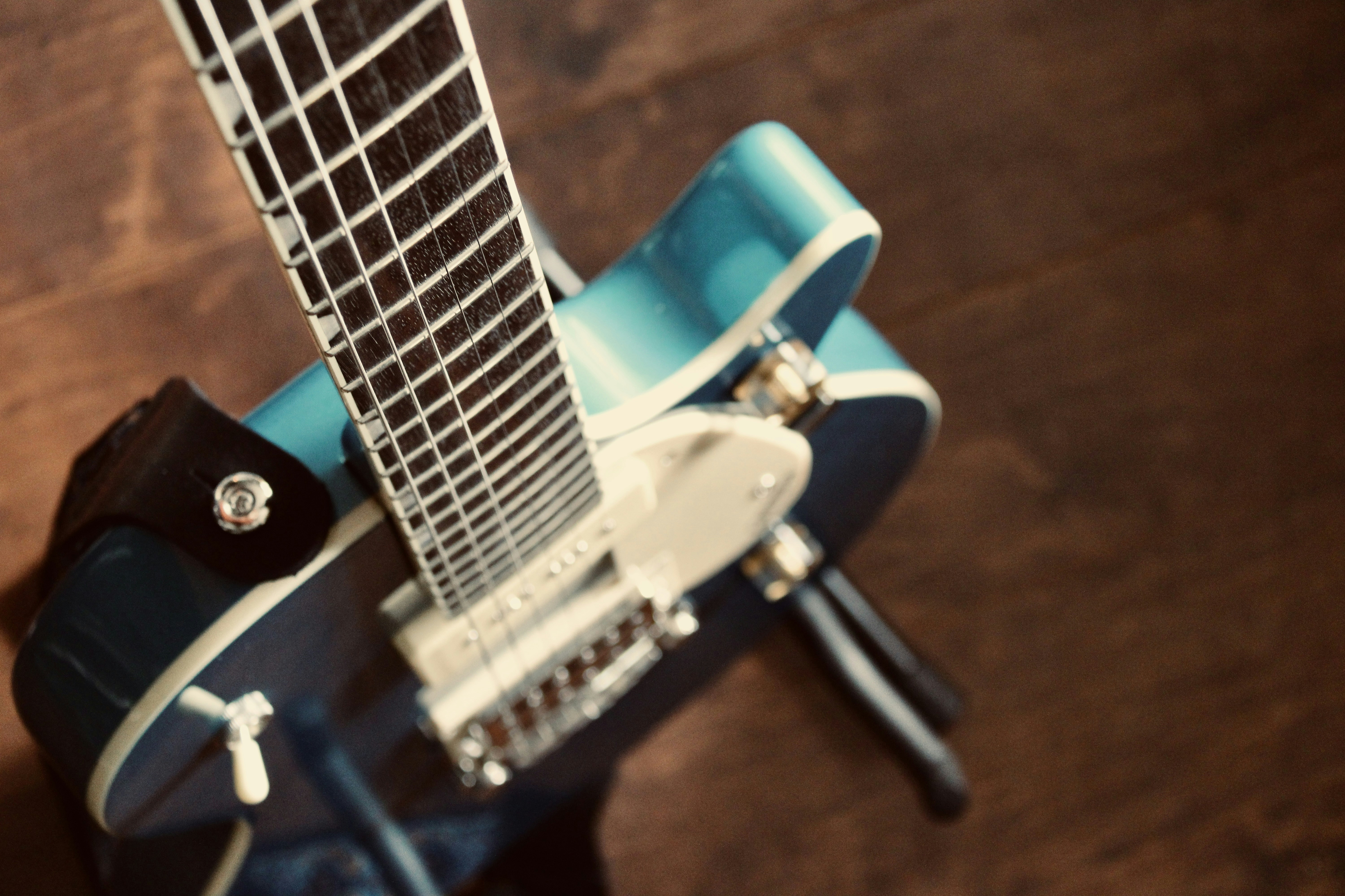 a blue guitar sitting on top of a wooden floor