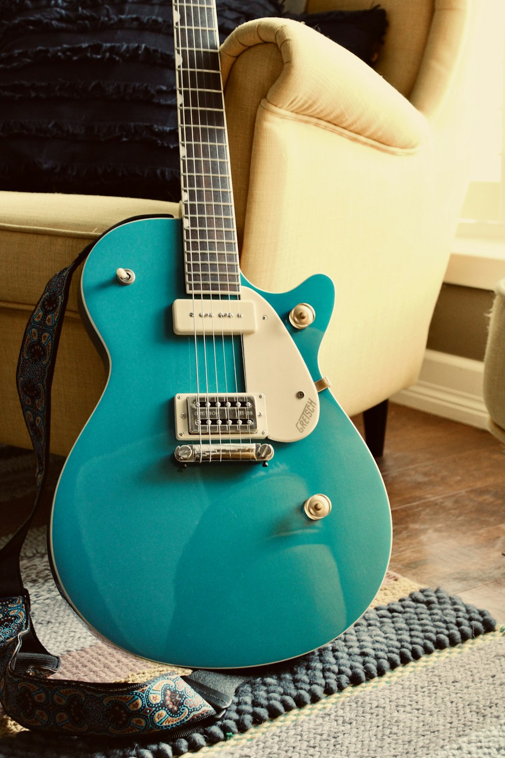 a blue guitar sitting on top of a rug