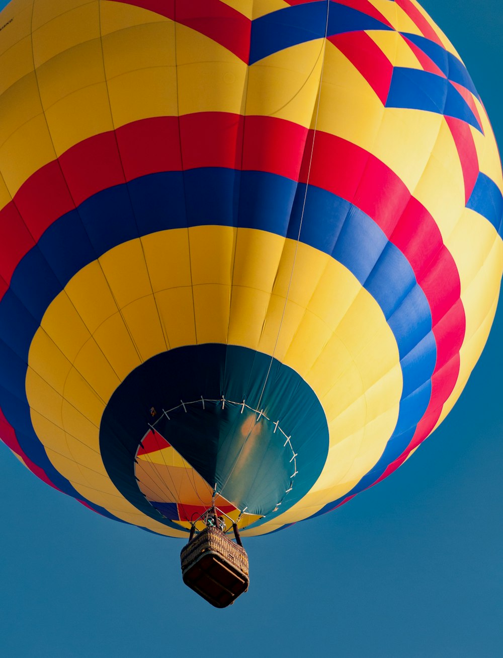 a large colorful hot air balloon flying through a blue sky