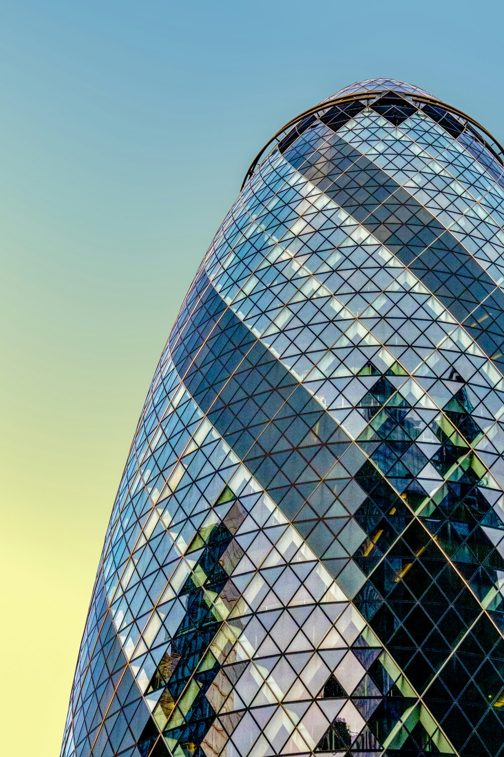 a very tall glass building with a clock on it's side