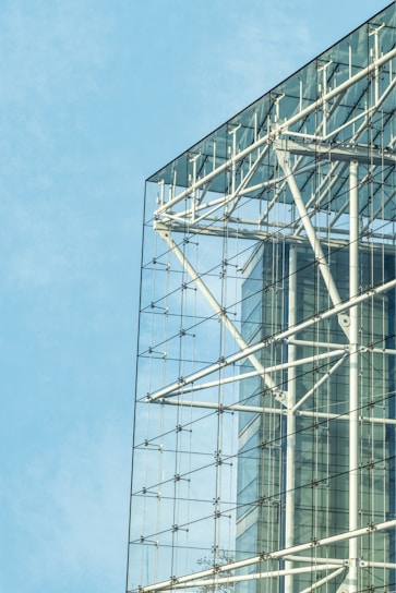 Modern industrial building with sleek structural steel framework under clear sky.