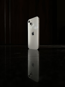 Sleek black and white photo of a modern smartphone on a minimalist white surface.