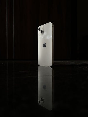 Sleek black and white photo of a modern smartphone on a minimalist white surface.