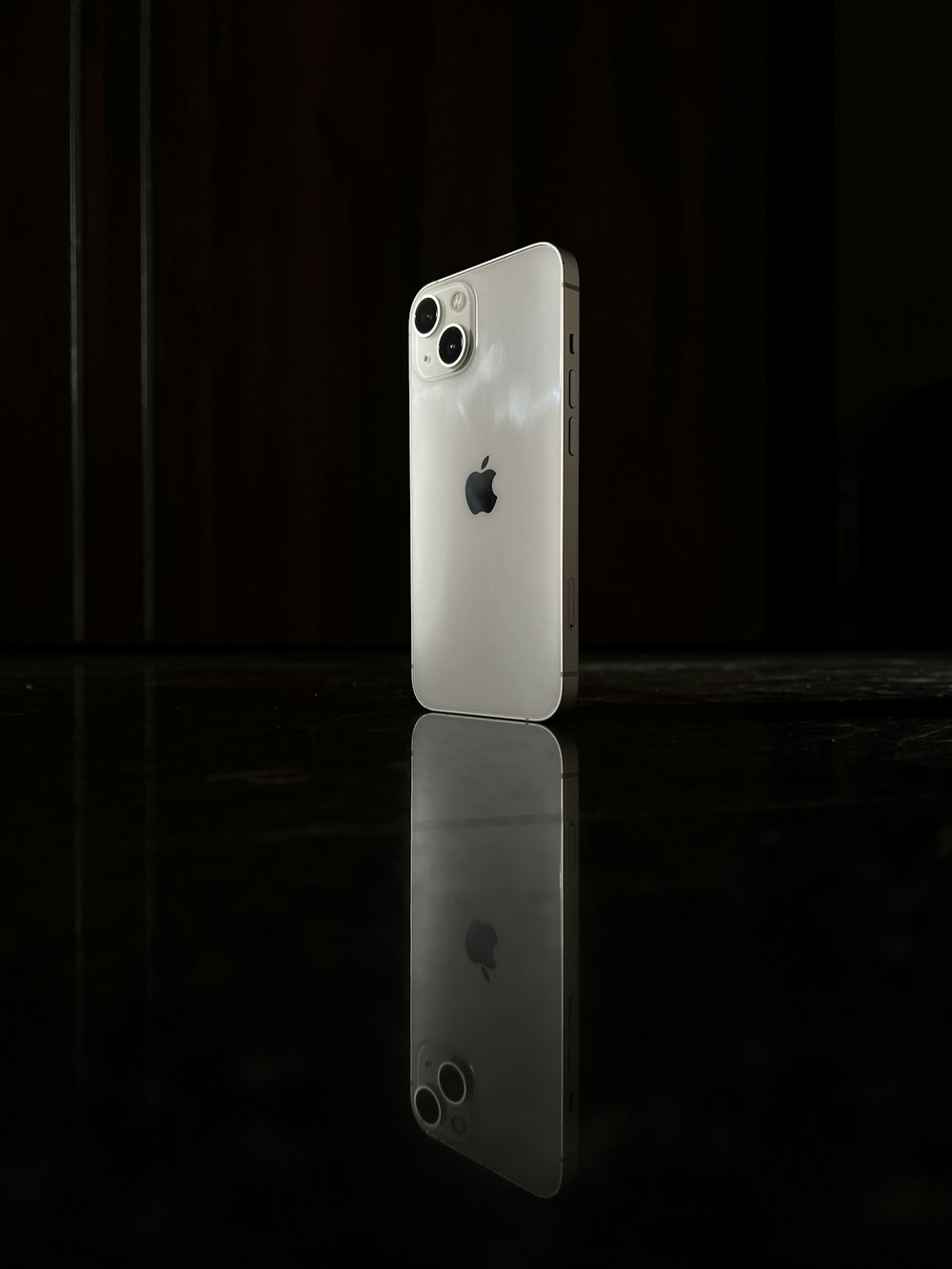 Un iPhone blanc assis sur une table noire