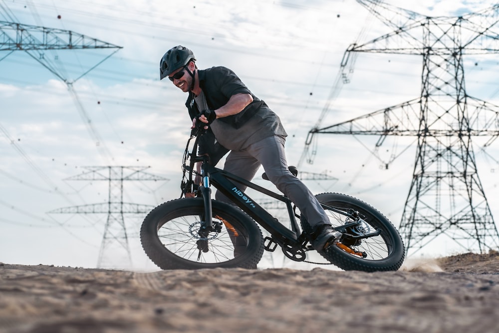 a man riding a bike down a dirt road