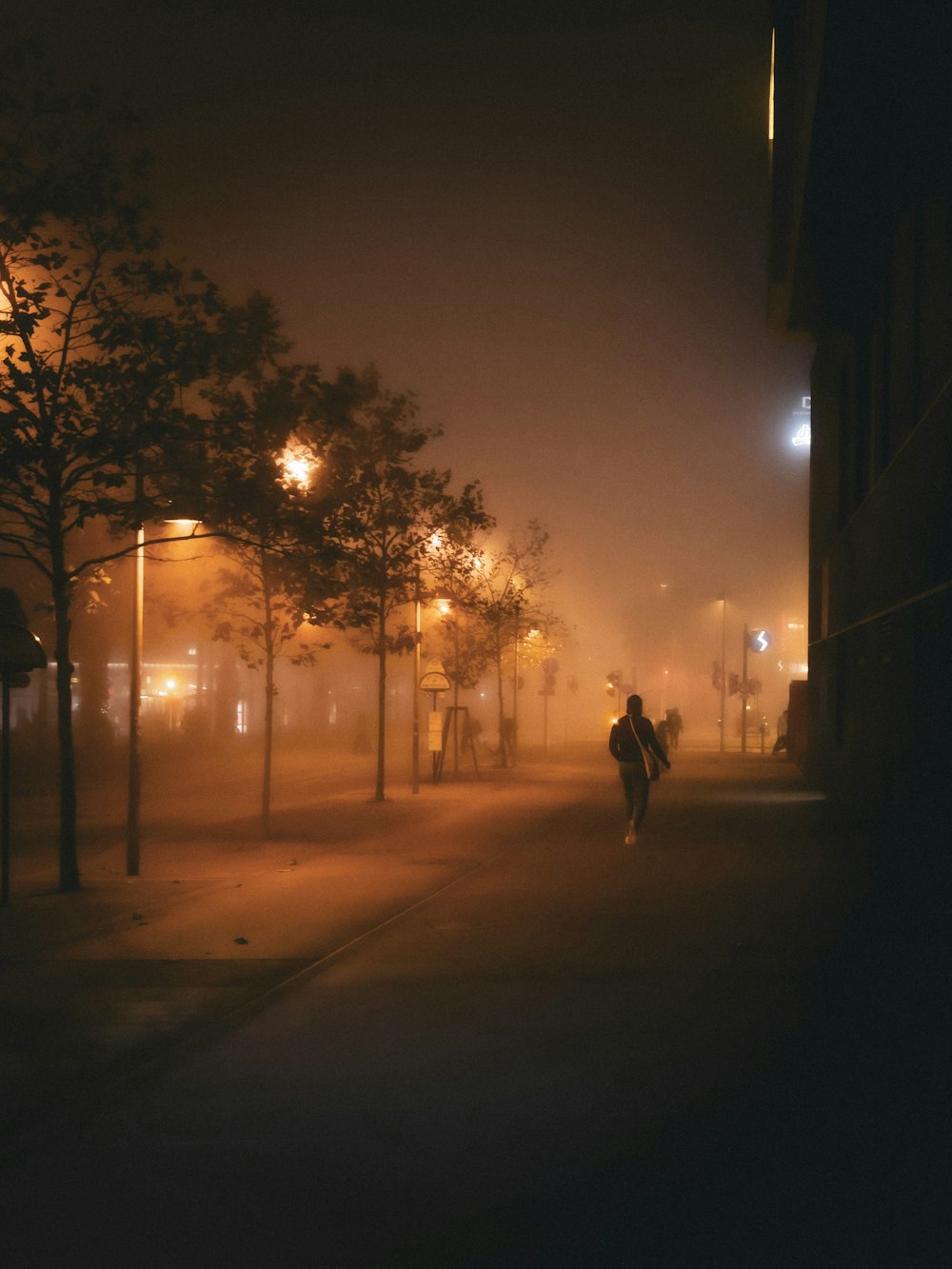 a person walking down a street at night