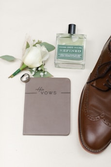 a pair of brown shoes next to a note and a flower