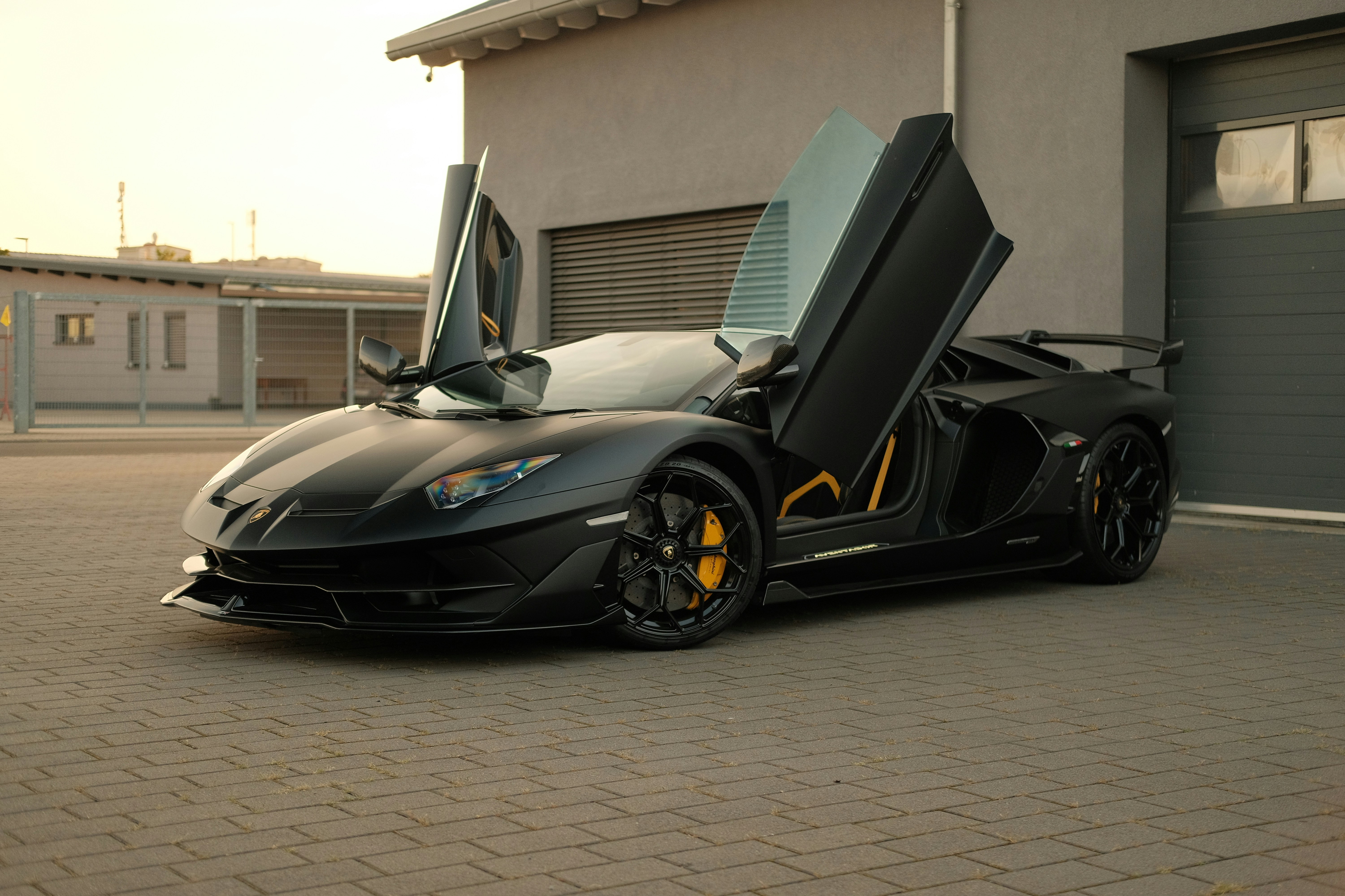 a black sports car parked in front of a garage