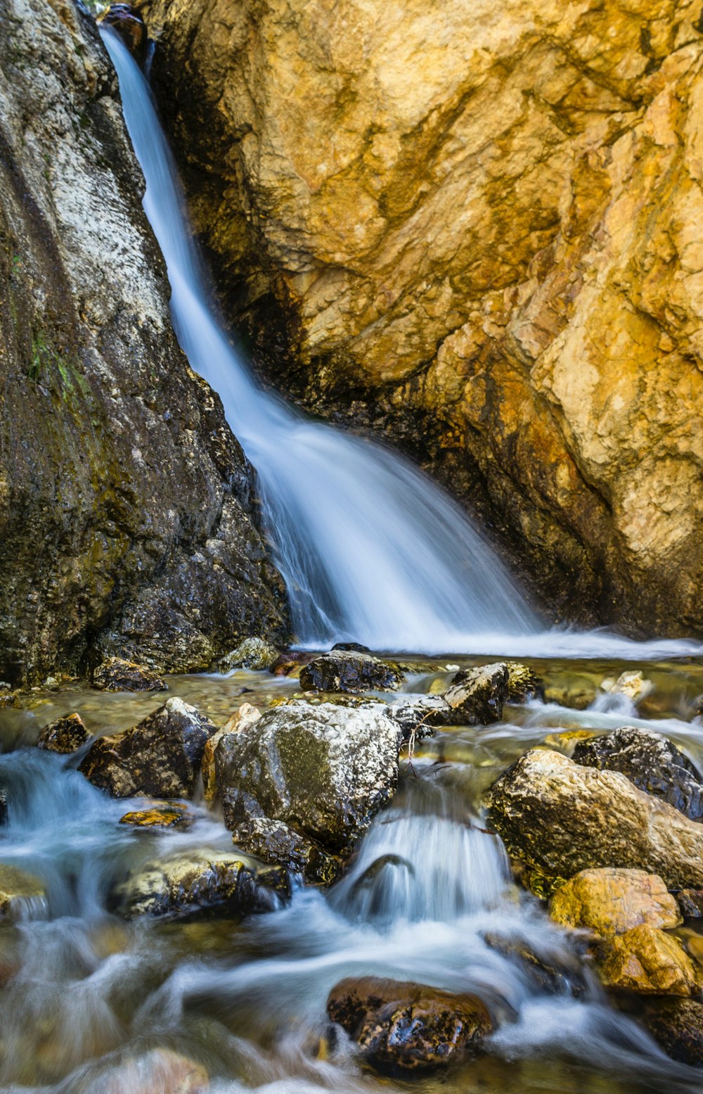a small waterfall flowing over rocks into a river