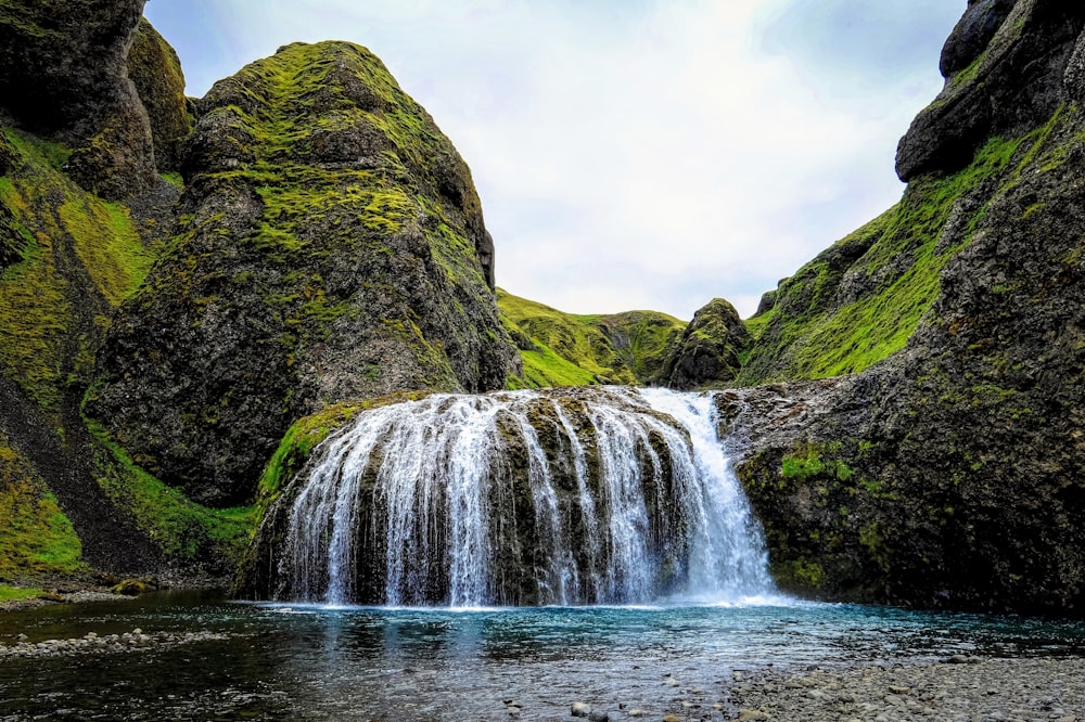 a small waterfall in the middle of a mountain