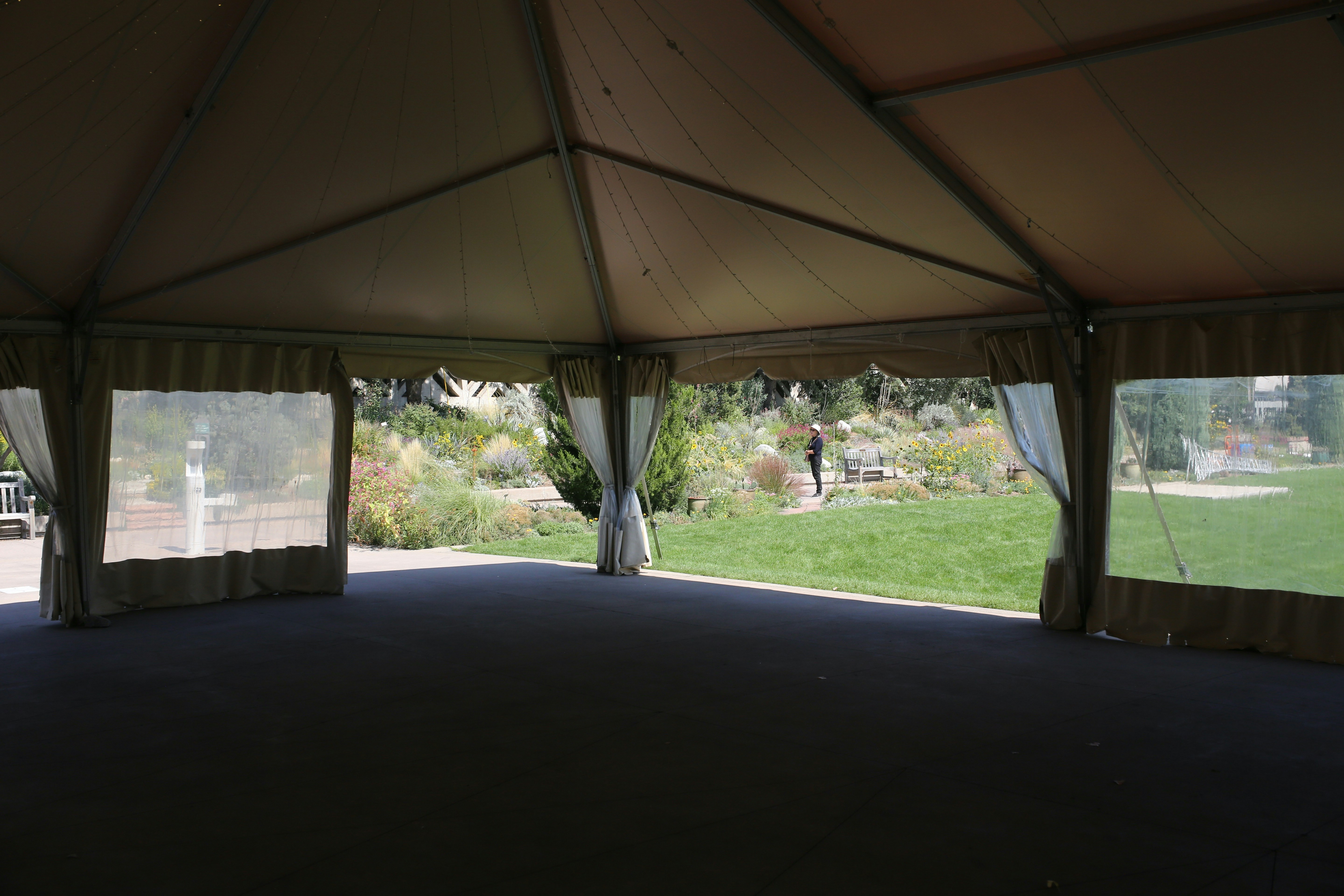 a large tent with curtains and a person walking in the distance