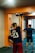 A fitness coach demonstrating an exercise in a gym with a client following along.