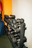 Dumbbell rack featuring polished weights arranged neatly against a textured industrial wall.