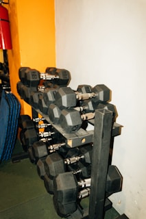 Dumbbell rack featuring polished weights arranged neatly against a textured industrial wall.