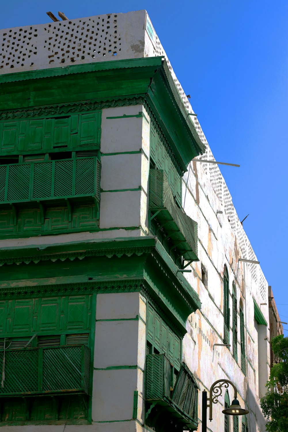 a green and white building with green shutters