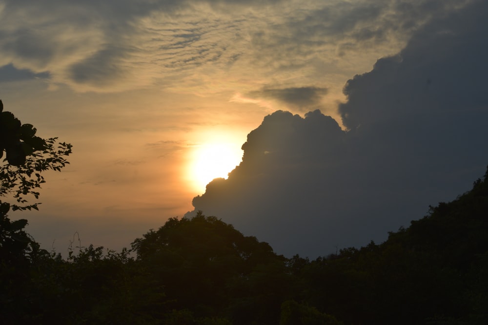 the sun is setting behind the clouds in the sky