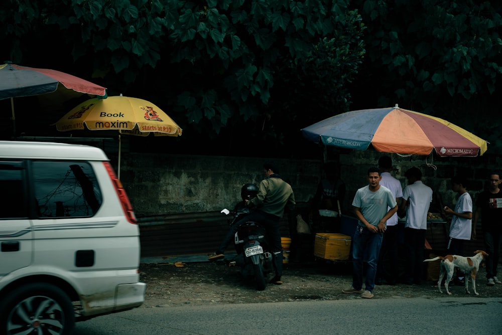 a group of people standing around a food stand