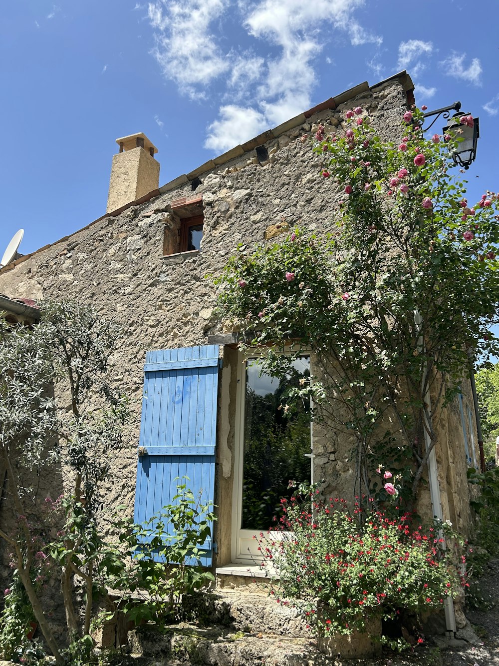 a stone building with a blue door and window