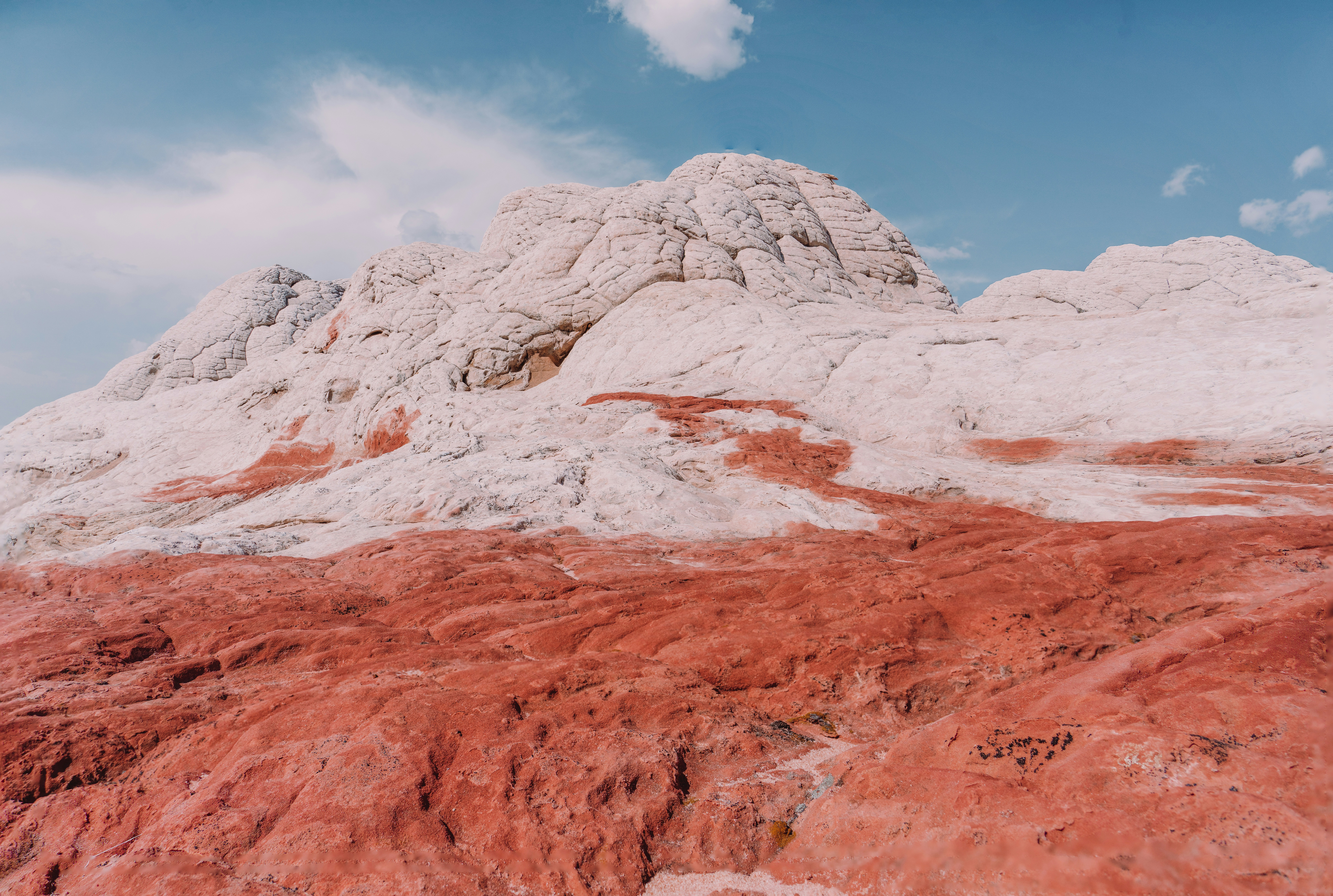 Una montaña cubierta de tierra roja bajo un cielo azul