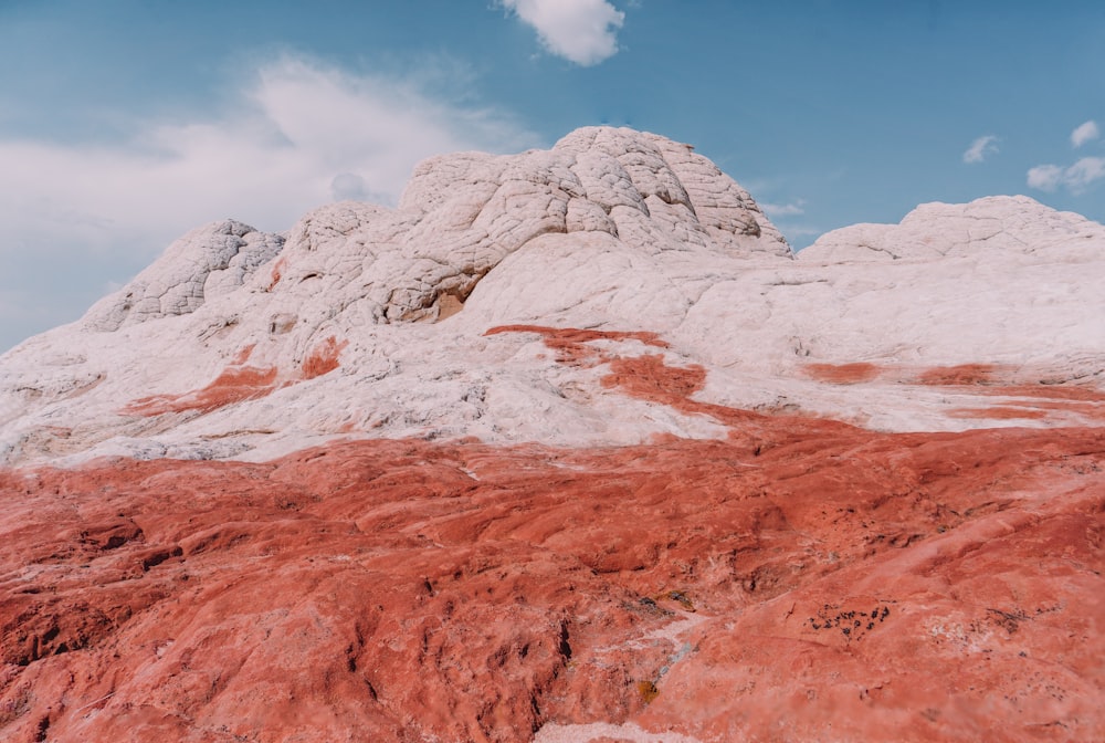 a mountain covered in red dirt under a blue sky