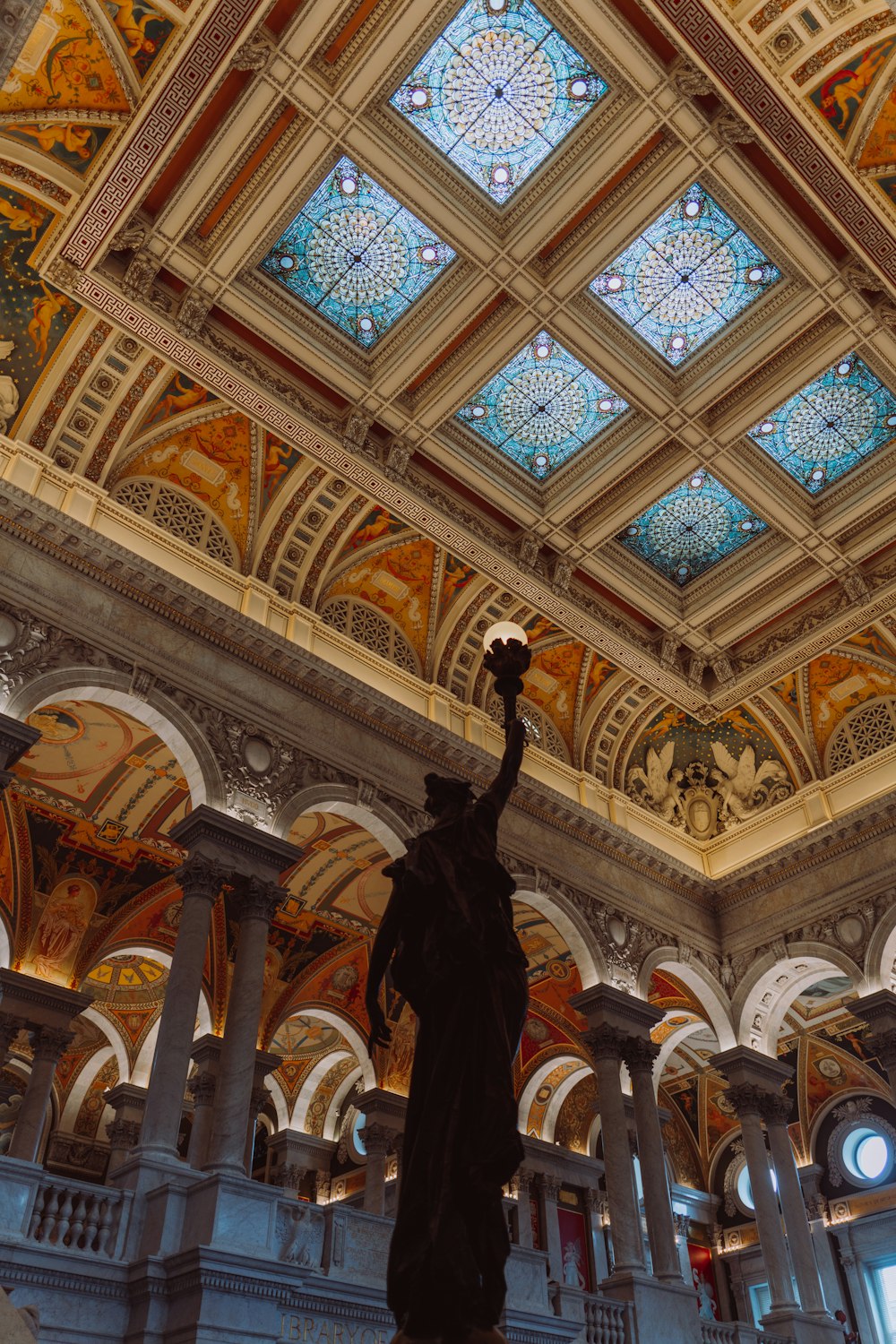 a statue in a building with a glass ceiling