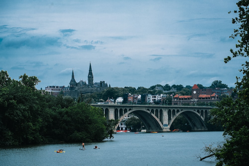 a bridge over a body of water with a city in the background