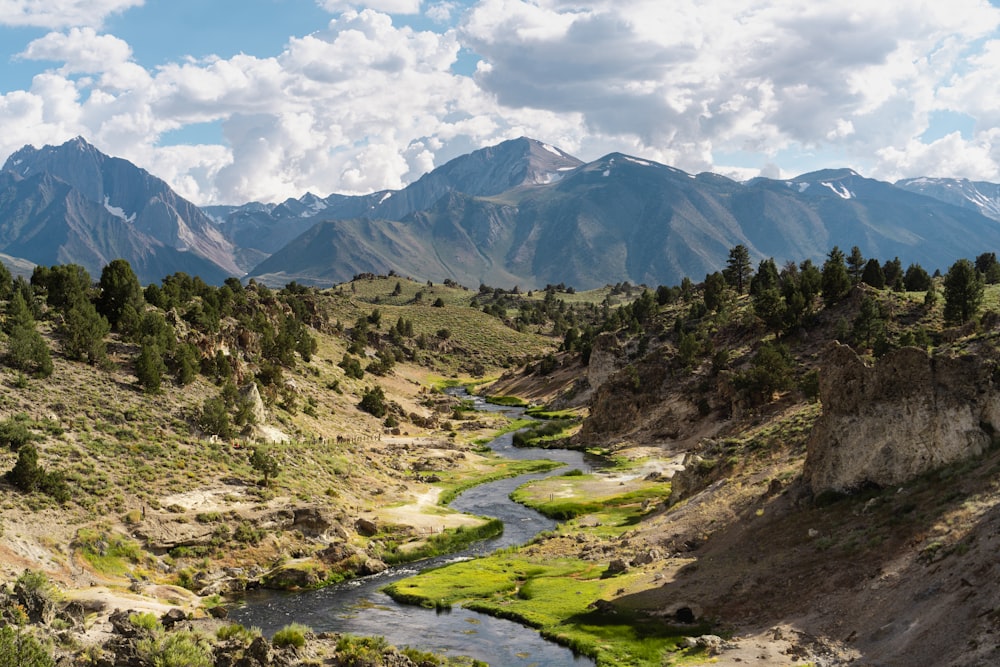 a river running through a valley surrounded by mountains