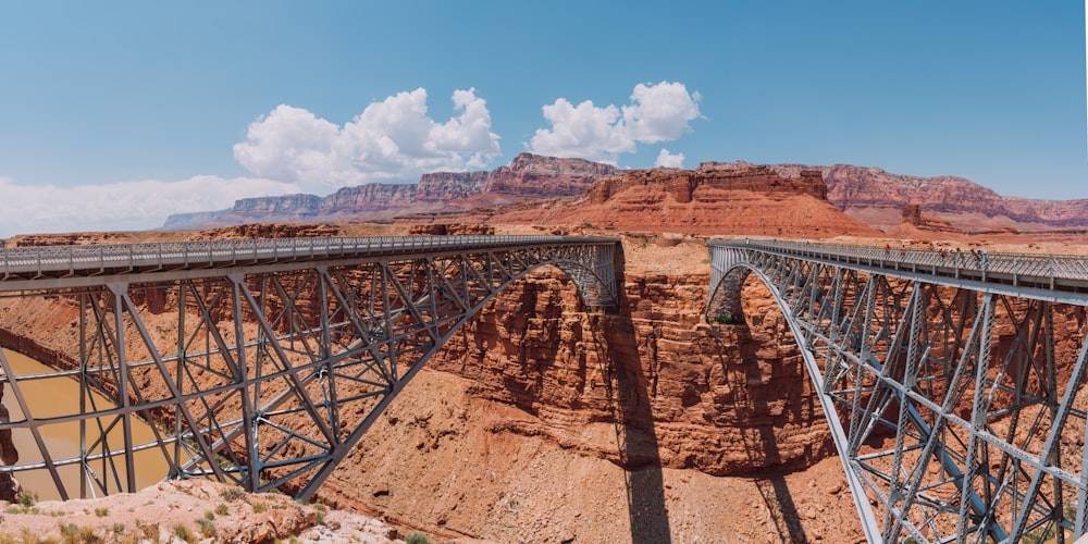 a large bridge over a canyon with a mountain in the background