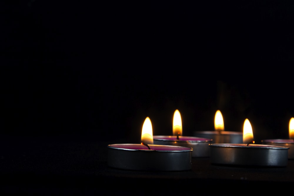 a group of lit candles sitting on top of a table