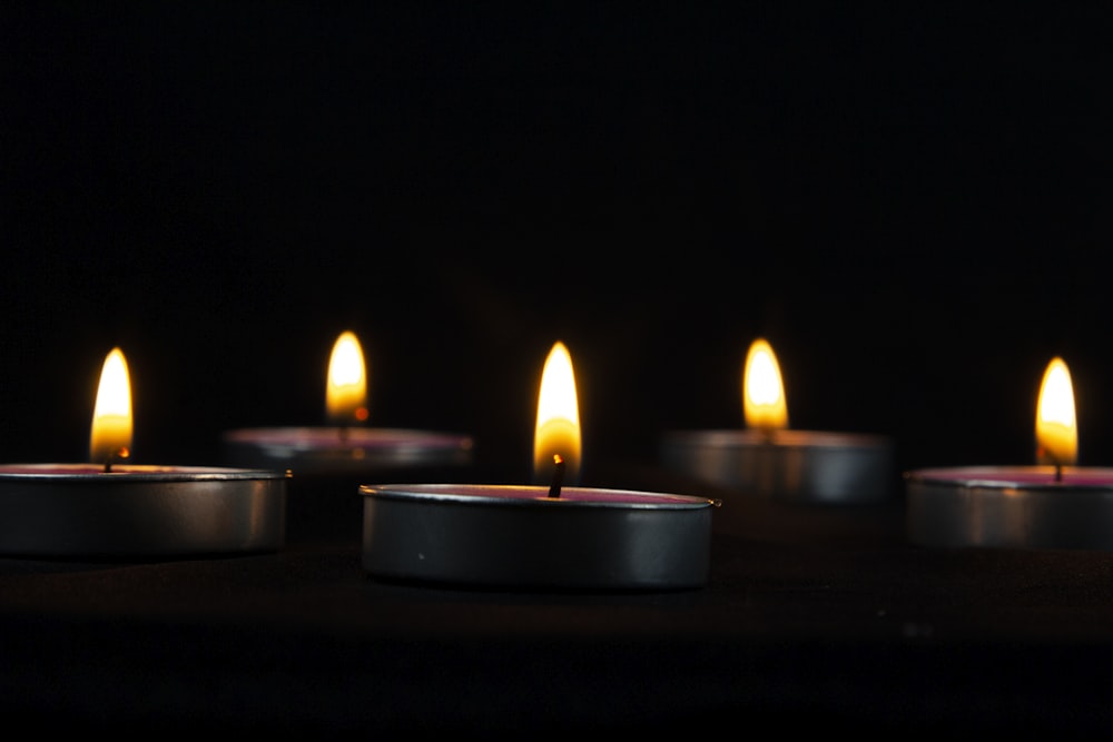 un gruppo di candele accese sedute sopra un tavolo