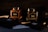 Two elegantly designed jars labeled 'Kindness' and 'Heaven,' containing apricot and raspberry products respectively, are placed against a dark background. The lighting highlights the rich colors of the contents, providing a luxurious and sophisticated atmosphere. Around the jars are various black and white cards with intricate designs.