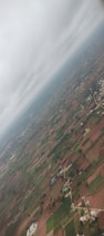 Aerial shot of farmland protected beneath a vast weather dome on a bright day.