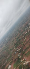 Aerial view of a vast Brazilian farmland with green fields and a clear blue sky.