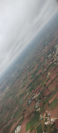 Aerial view of a vast rural farm landscape in Floriano, Piauí, with green fields and clear skies.