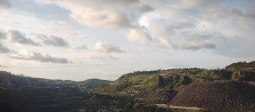 Restored mining site with green vegetation and clear skies
