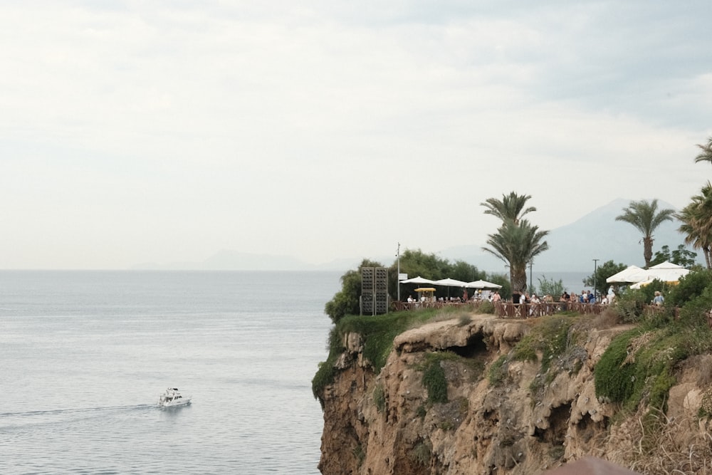 a boat is in the water near a cliff