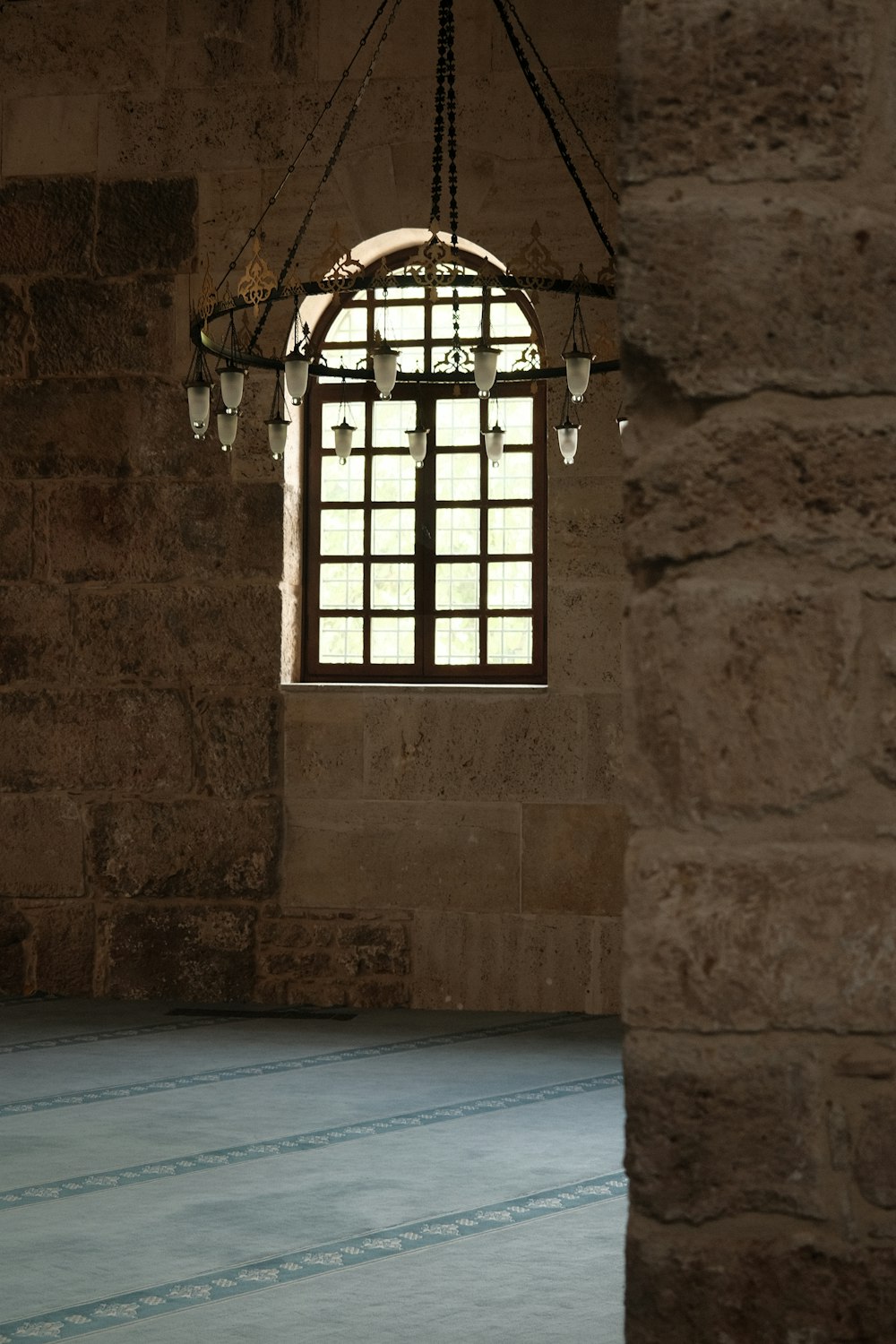 a window in a stone building with a light hanging from it