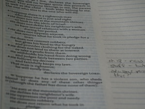 Close-up of a student reading scripture with notes in a quiet study space.